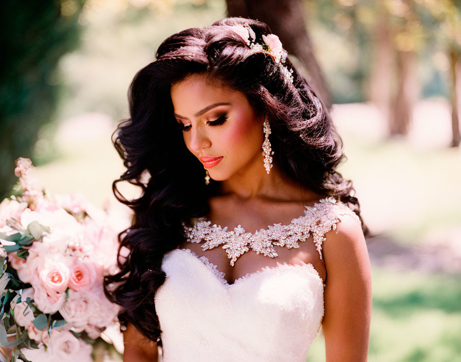 Bride with wavy hair in strapless gown outdoors by flowers