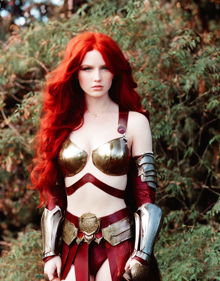 Red-haired person in gold and red fantasy armor costume against green foliage