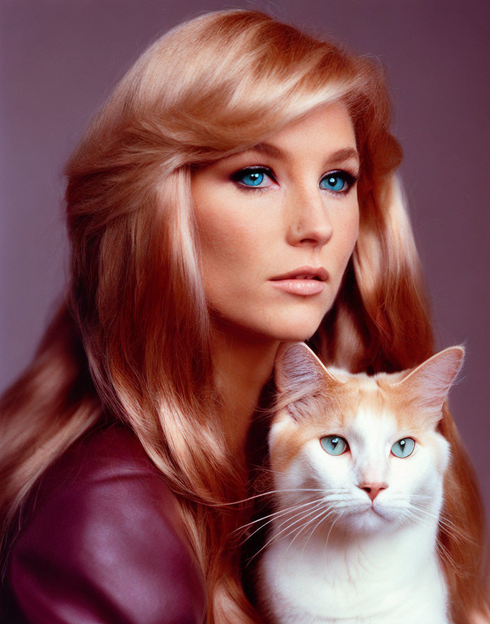 Blonde woman with blue eyes poses with orange and white cat