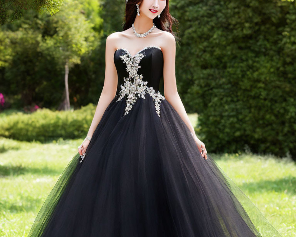 Elegant woman in black strapless ball gown with silver embellishment in lush garden