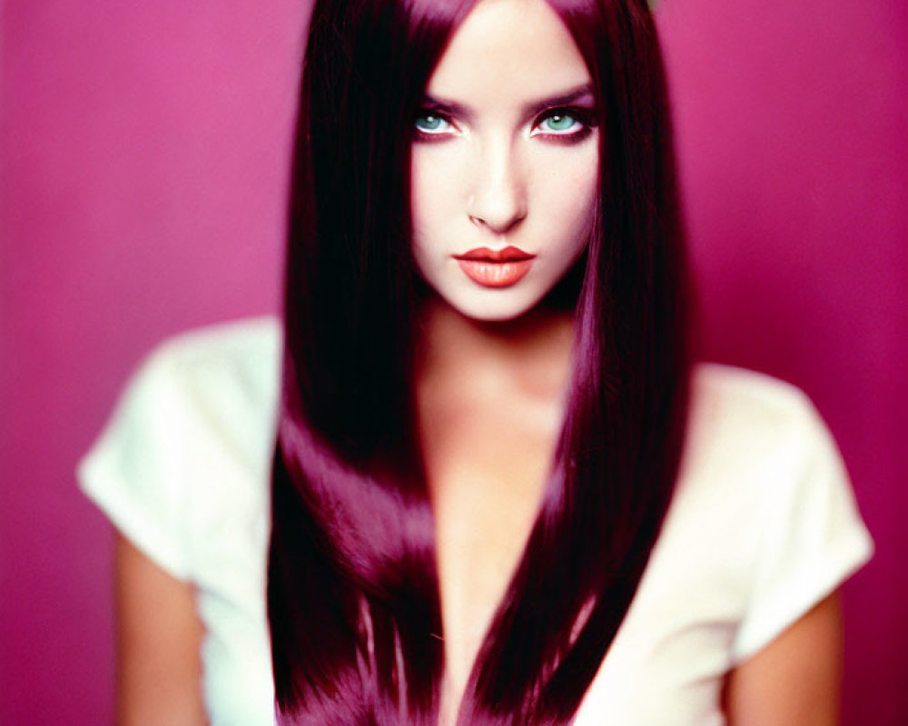 Burgundy-haired woman with blue eyes in white top and floral headpiece