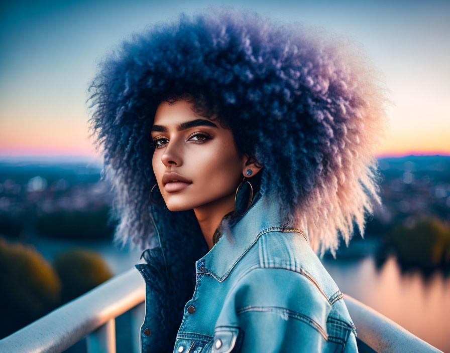 Woman with Voluminous Afro Hair in Denim Jacket against Sunset Cityscape