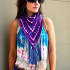 Vibrant tie-dye scarf and bohemian jewelry on woman against rocky backdrop