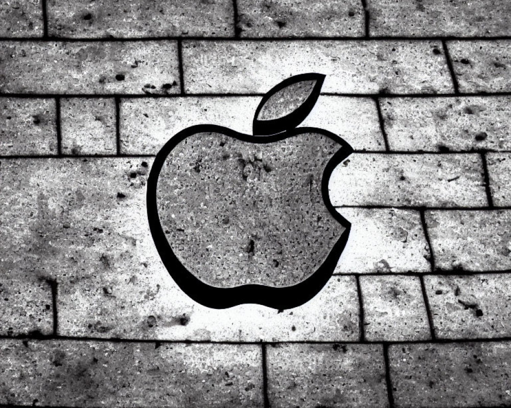 Apple logo silhouette on textured brick surface - etched shadow effect