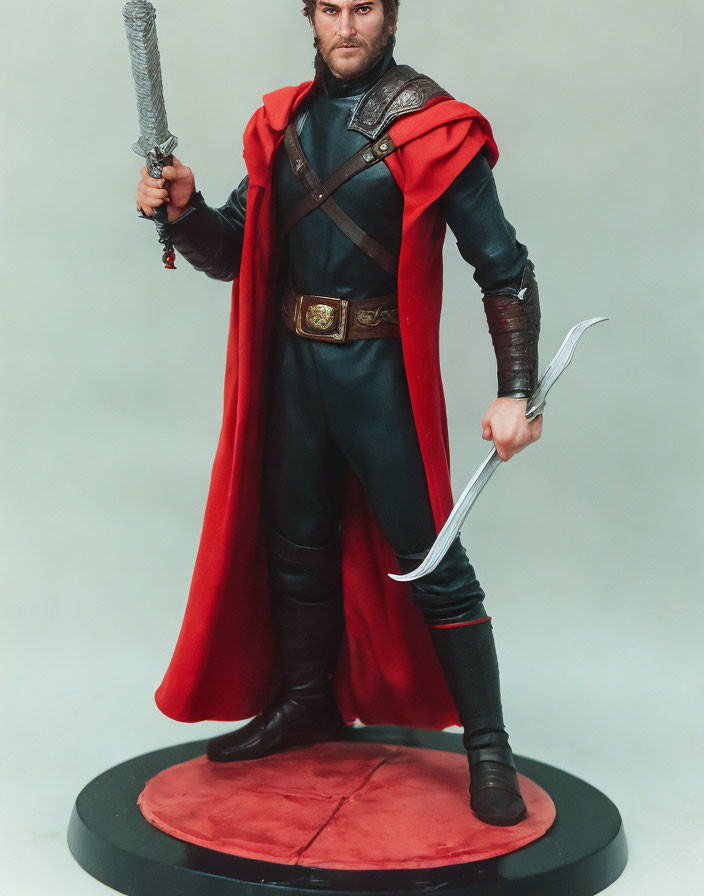 Medieval armor figure with red cape, sword, and dagger on circular base