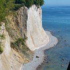 Verdant cliffside overlooking serene beach and blue waters