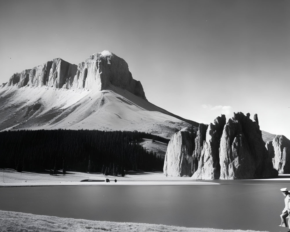 Monochrome landscape with mountain, lake, and person in wide-brimmed hat