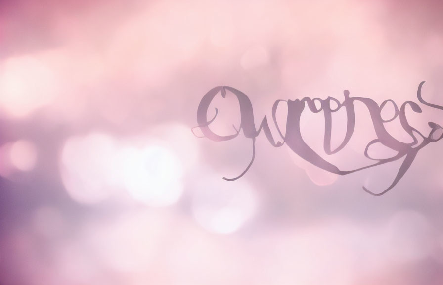 Elegant script on soft pink bokeh background