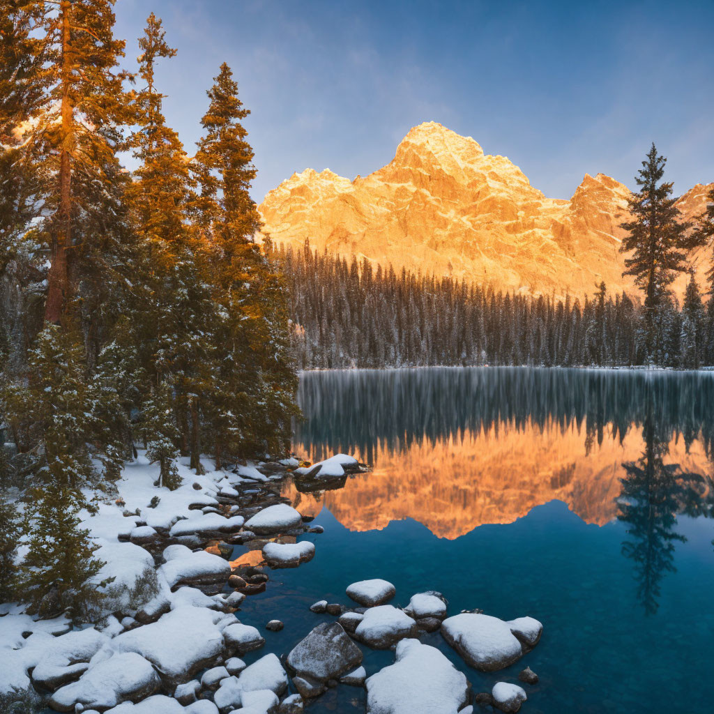 Snow-capped mountains reflected in serene alpine lake at sunrise