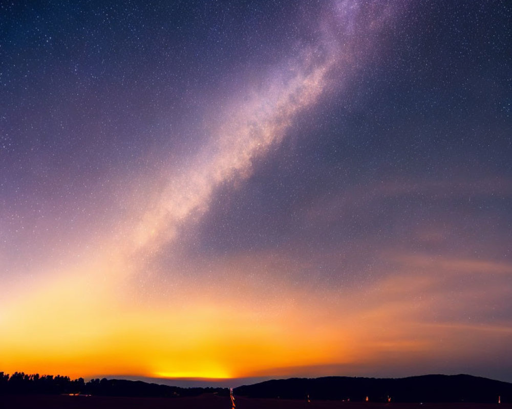 Starry Milky Way over sunset gradient with road in night sky