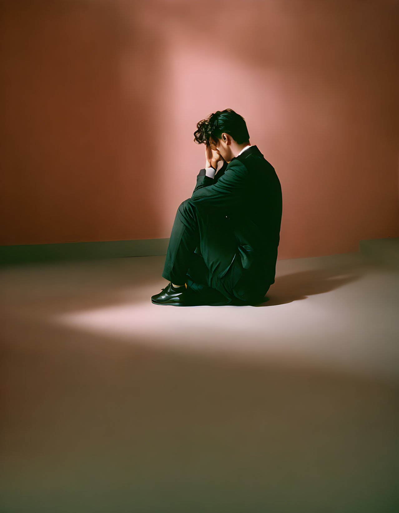 Distressed Person in Suit Sitting on Floor in Spotlight