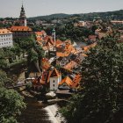 Fairytale village painting with cozy houses and lush green trees