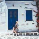 Surreal painting of woman on balcony with ships and birds in blue and white setting