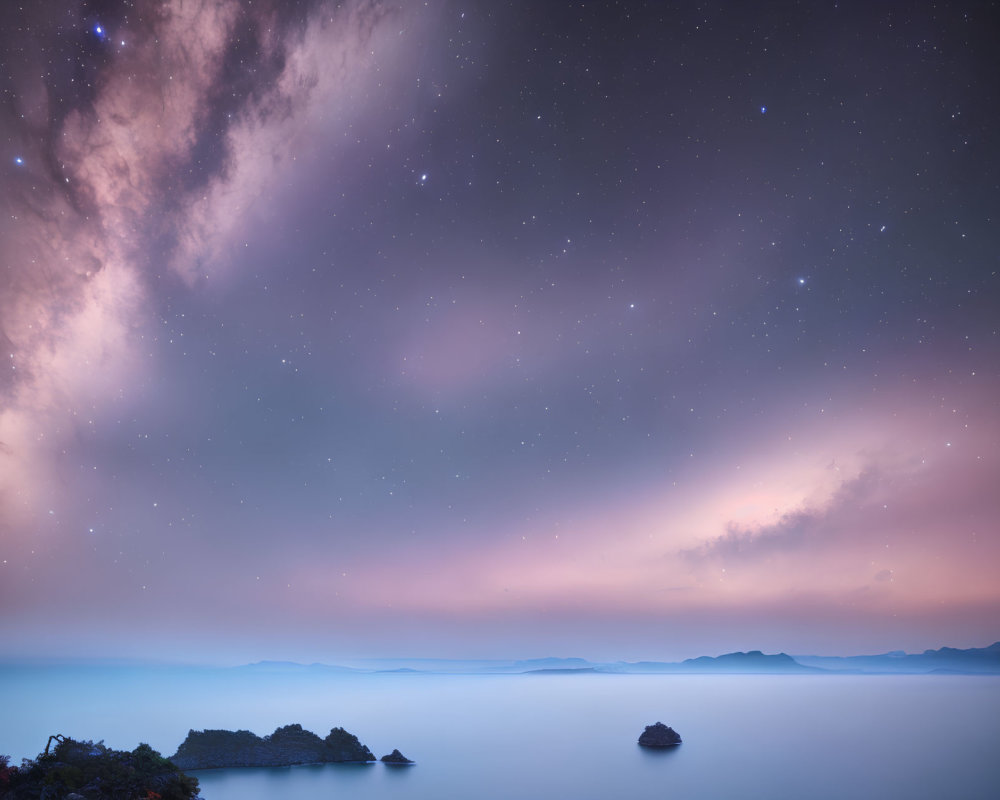 Twilight sky with Milky Way galaxy over calm sea and distant islands in blue to pink hues