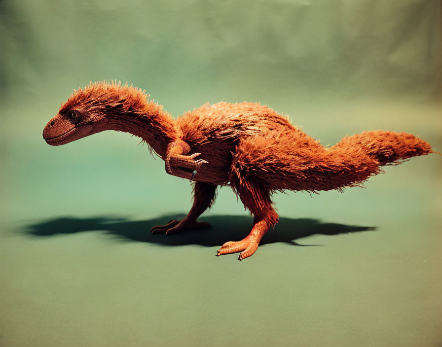 Realistic feathered dinosaur model with elongated body and bushy tail on green backdrop