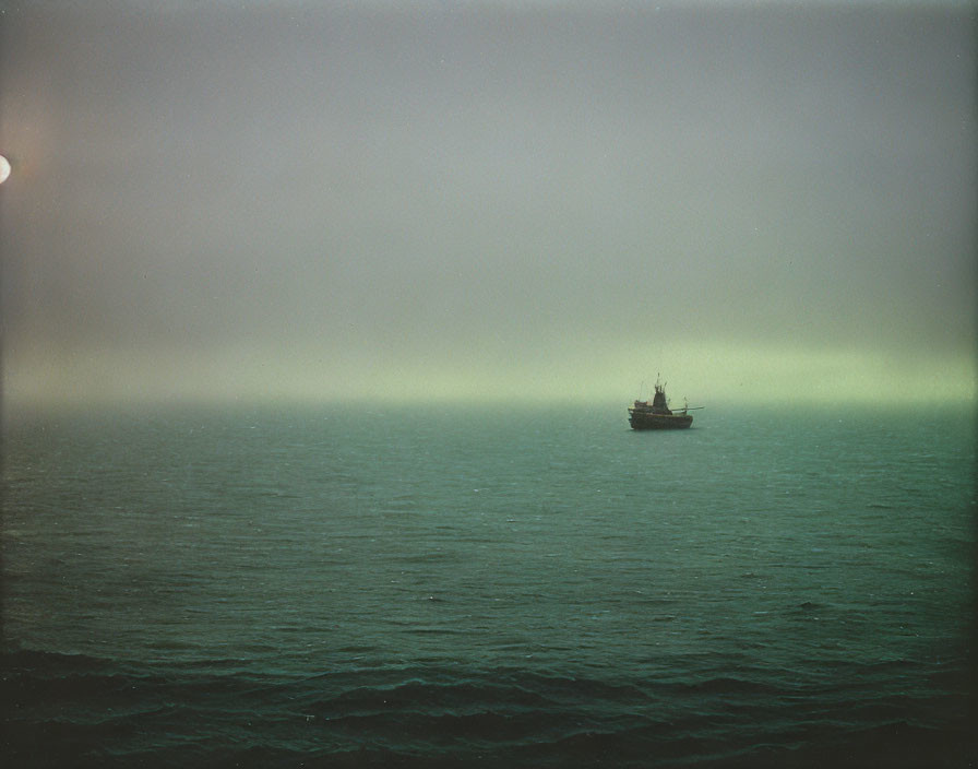 Misty Sea Scene: Lone Boat, Soft Glow, Murky Sky