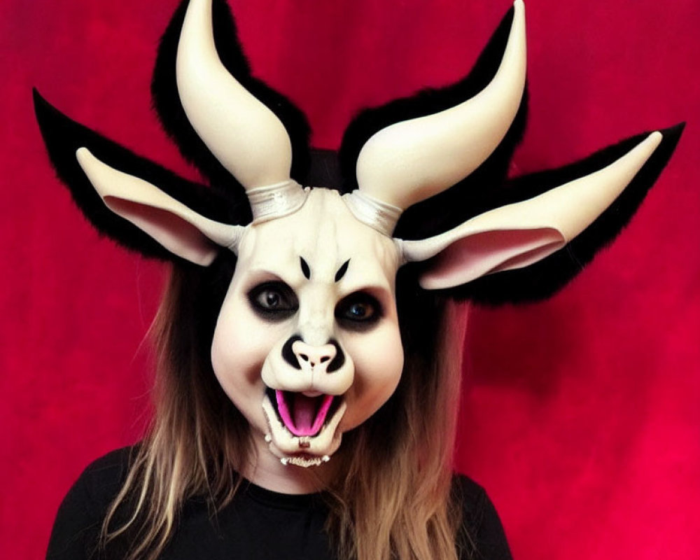 Person in Goat-Like Mask with Twisted Horns on Red Background