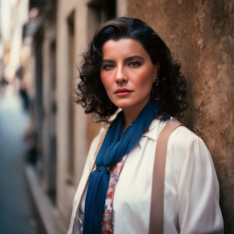 Confident woman in white blouse and blue scarf on city street