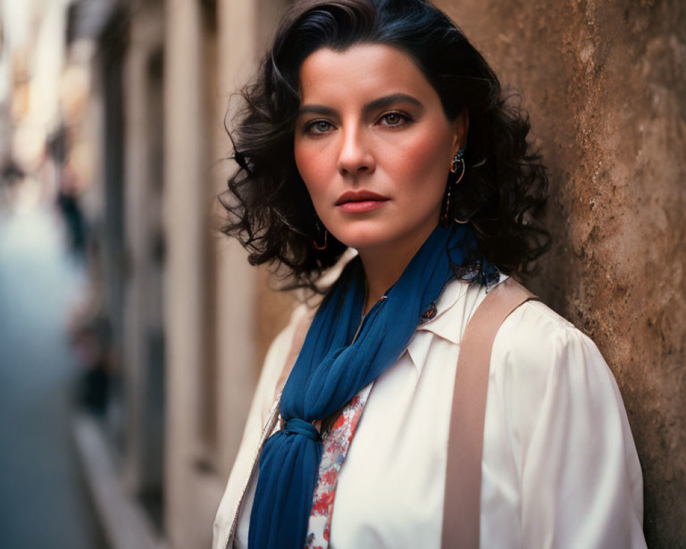 Confident woman in white blouse and blue scarf on city street