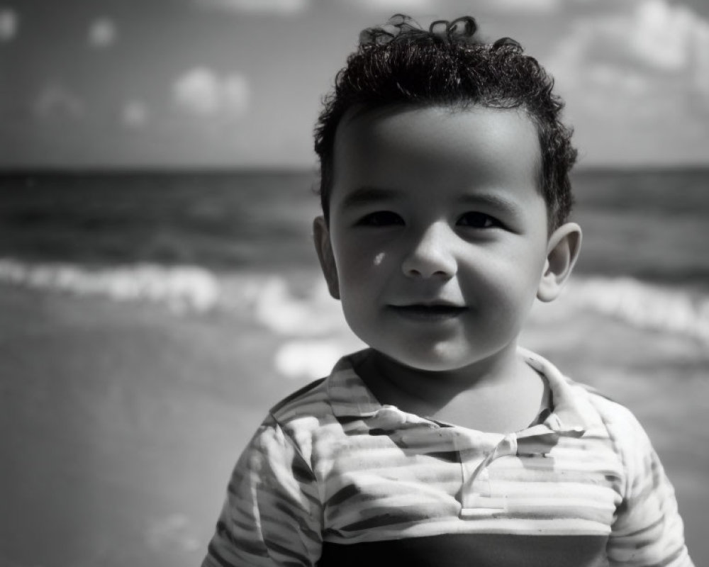 Curly-Haired Child Smiling on Beach in Black and White