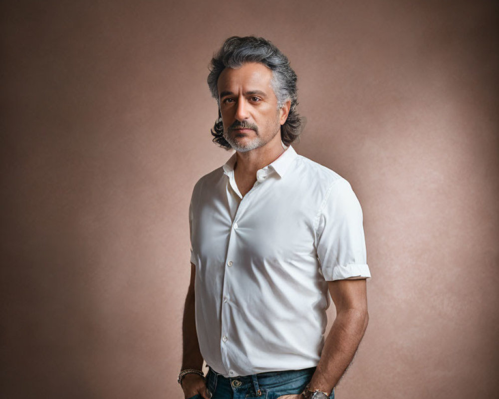 Gray-Haired Man in White Shirt and Jeans on Neutral Background