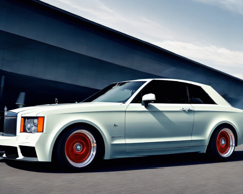 Luxury White Coupe with Black Roof & Red Wheels in Motion