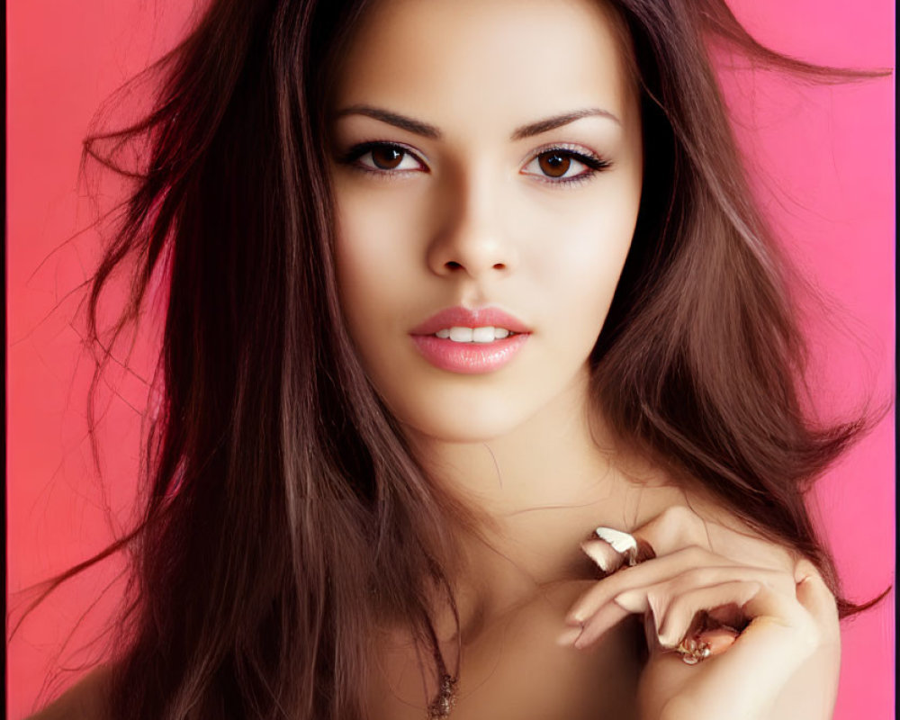 Portrait of a Woman with Flowing Brown Hair on Pink Background