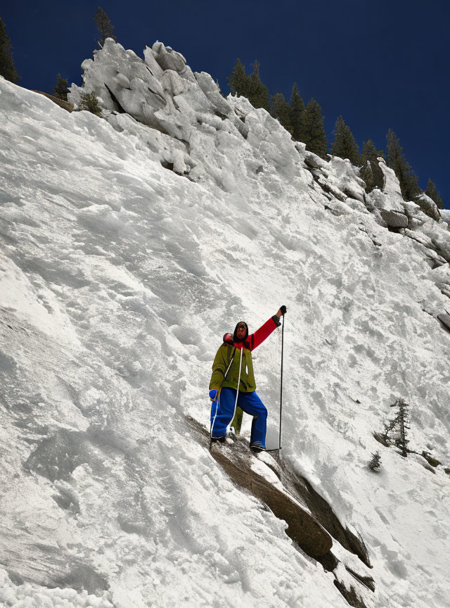 Colorful Gear Climber Celebrating Victory on Snowy Mountain