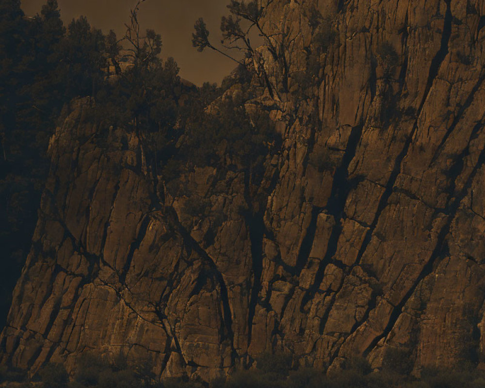 Sepia-toned image of rugged rocky cliff with vertical crevices