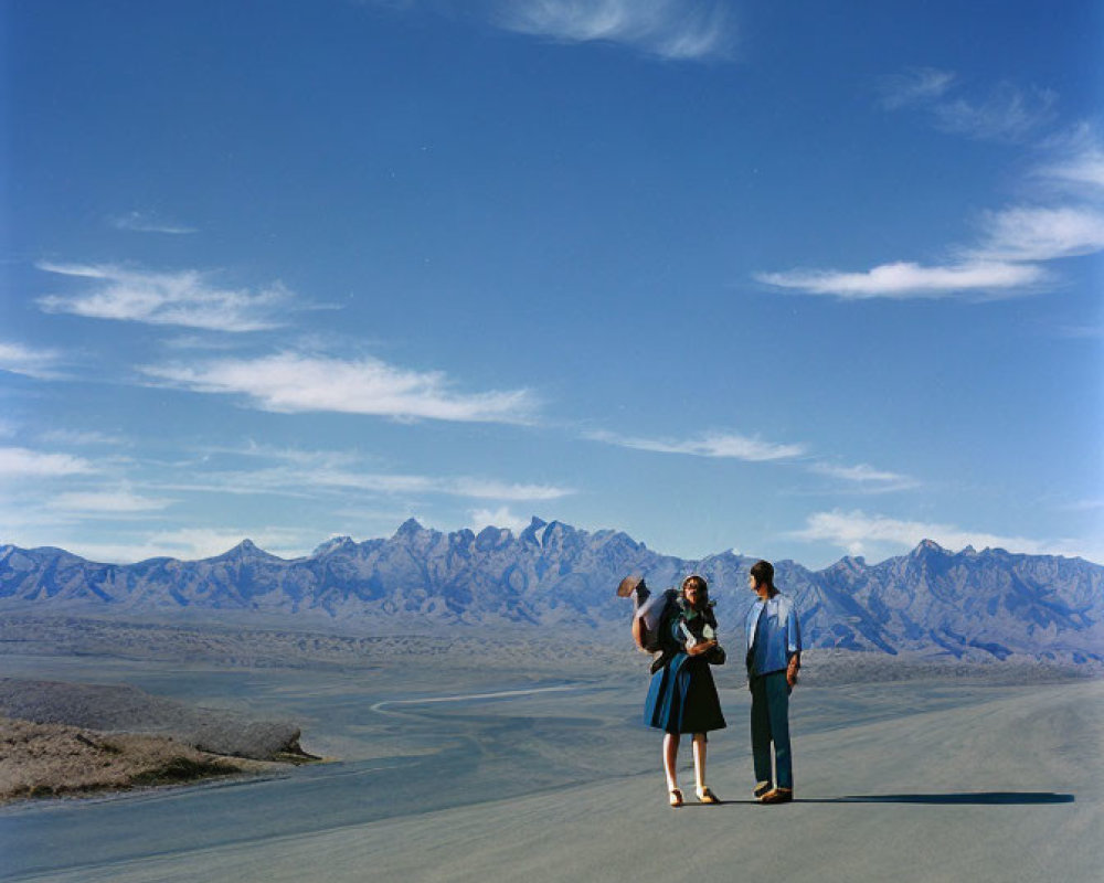 Three People on Barren Landscape with Clear Sky & Distant Mountains