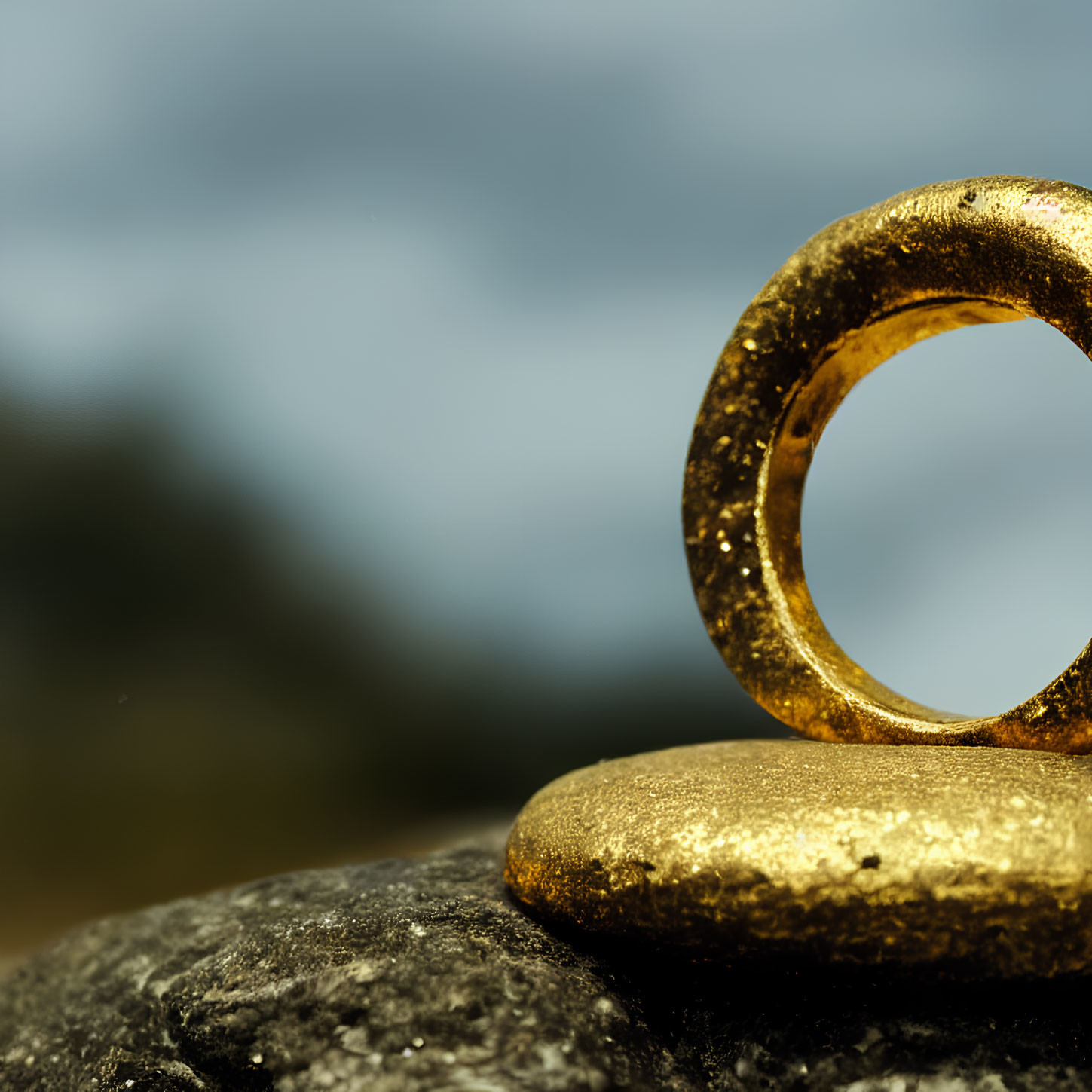 Golden ring on stone with blurred natural background