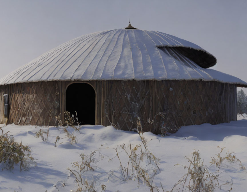 Round wooden yurt with snow-covered conical roof in snowy landscape