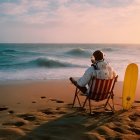 Person in White Spacesuit on Director's Chair by Sunset Coast with Surfboard, Sea of Clouds