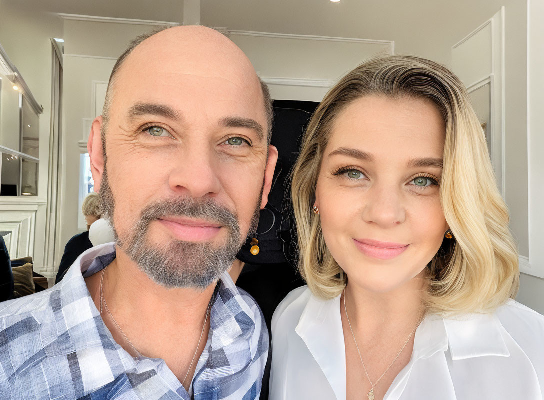 Smiling bald man with beard and blonde woman posing for a selfie