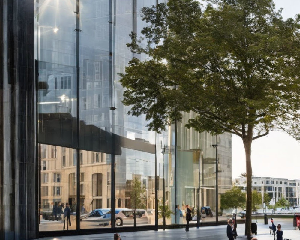 People outside modern glass building in urban plaza.