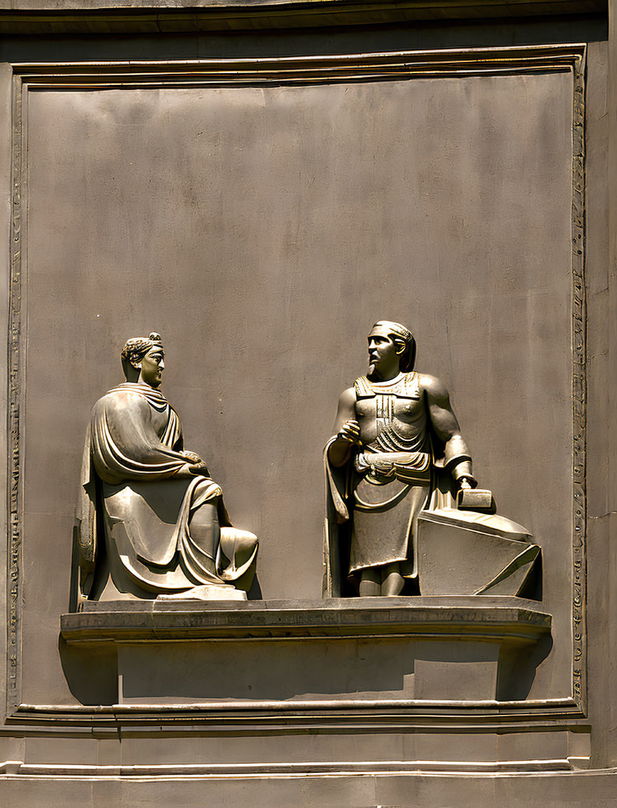 Bronze relief sculptures of seated and standing figures in conversation