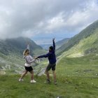 Joyful individuals in floral swimsuits dancing in vibrant, flower-filled landscape