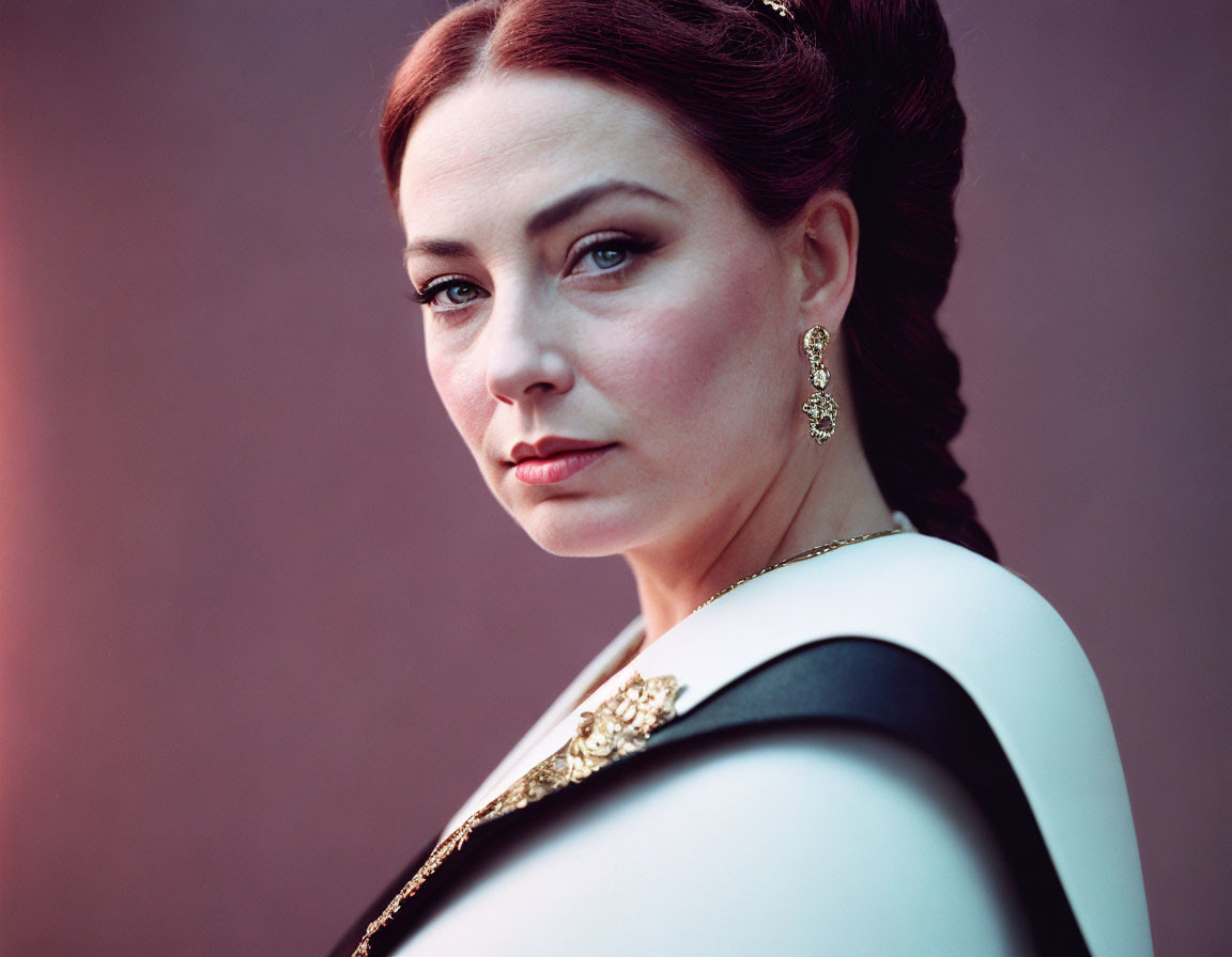 Porcelain-skinned woman in black and white outfit with red lips and gold earrings.