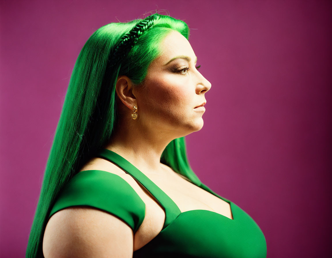 Vibrant green-haired woman in side profile against purple background