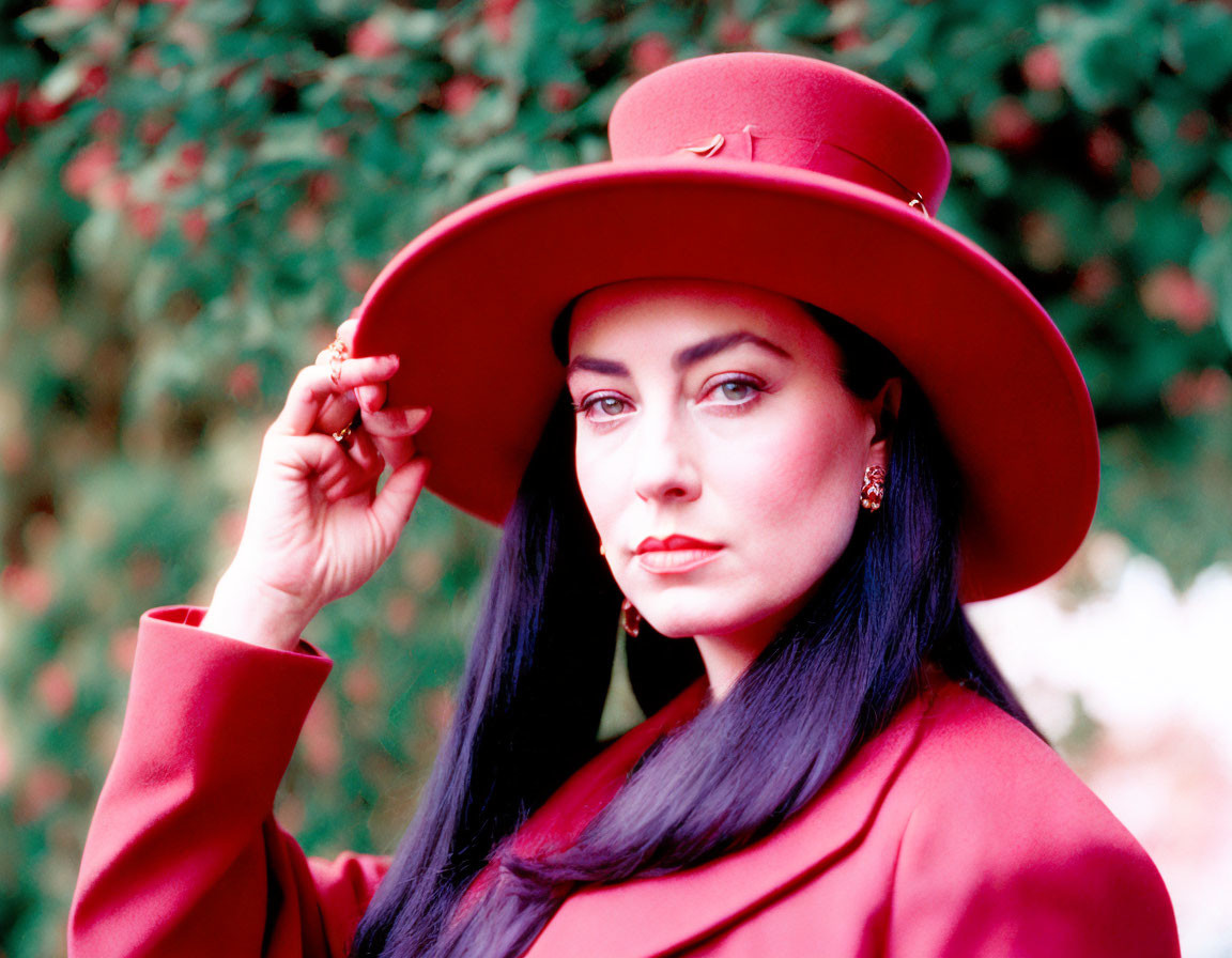 Woman in Red Hat and Coat Poses with Green Foliage Background