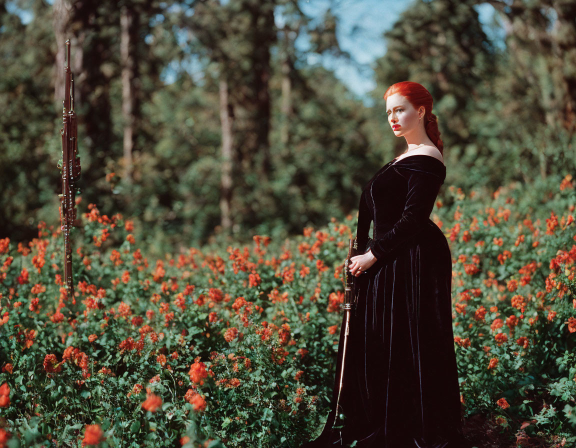 Red-haired woman in black dress with sword among red flowers in forest setting