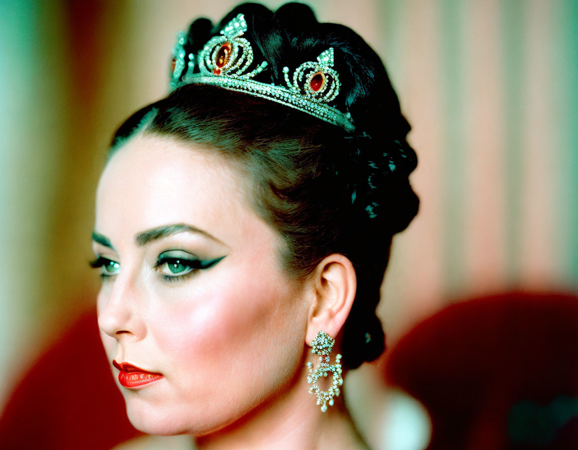 Regal woman in tiara with glamorous makeup gazes aside.