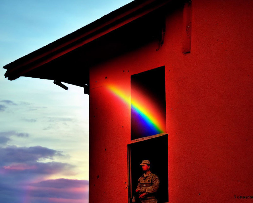 Camouflaged soldier beside building with colorful light spectrum at sunset