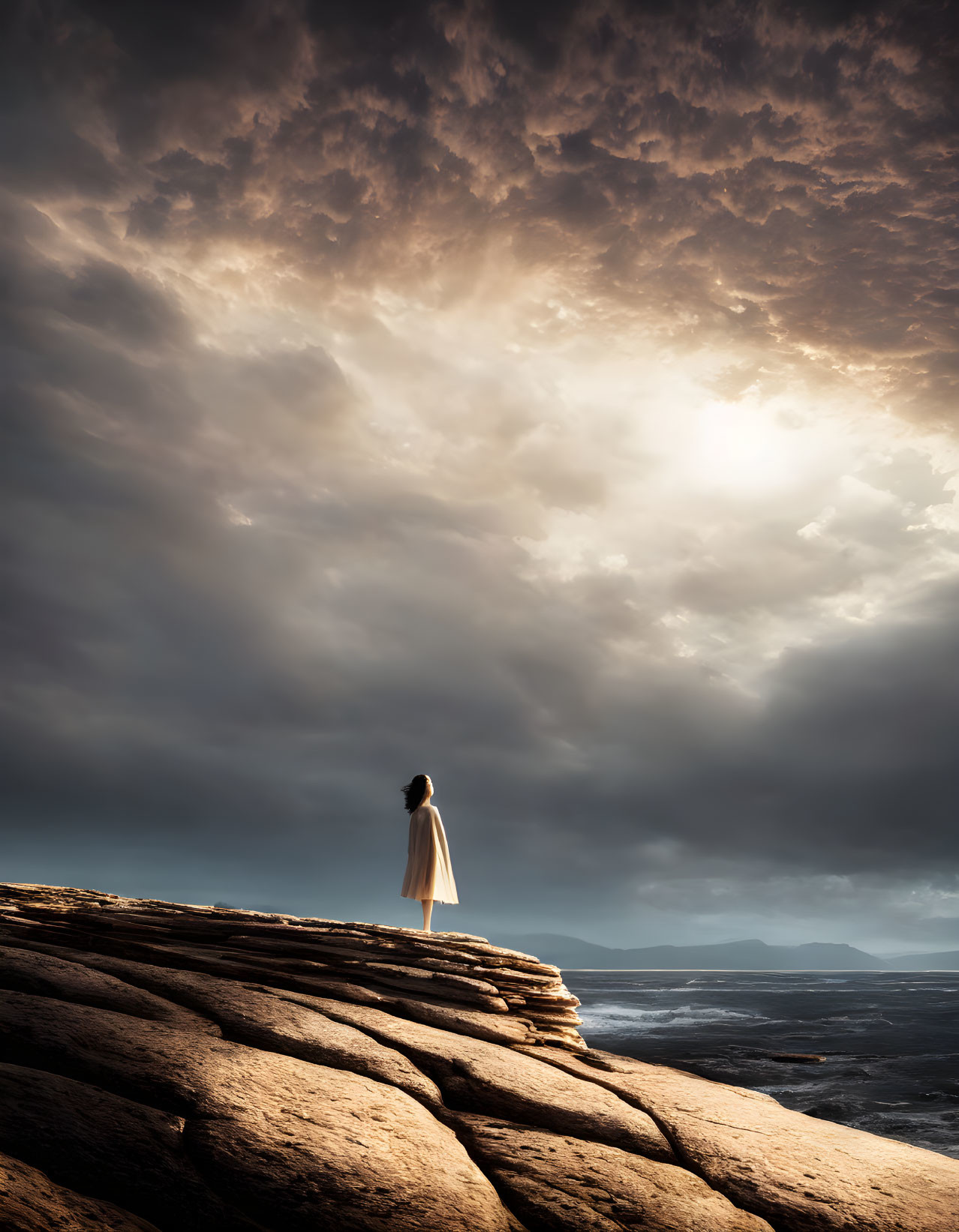 Figure on Layered Rock Cliff Overlooking Stormy Sea