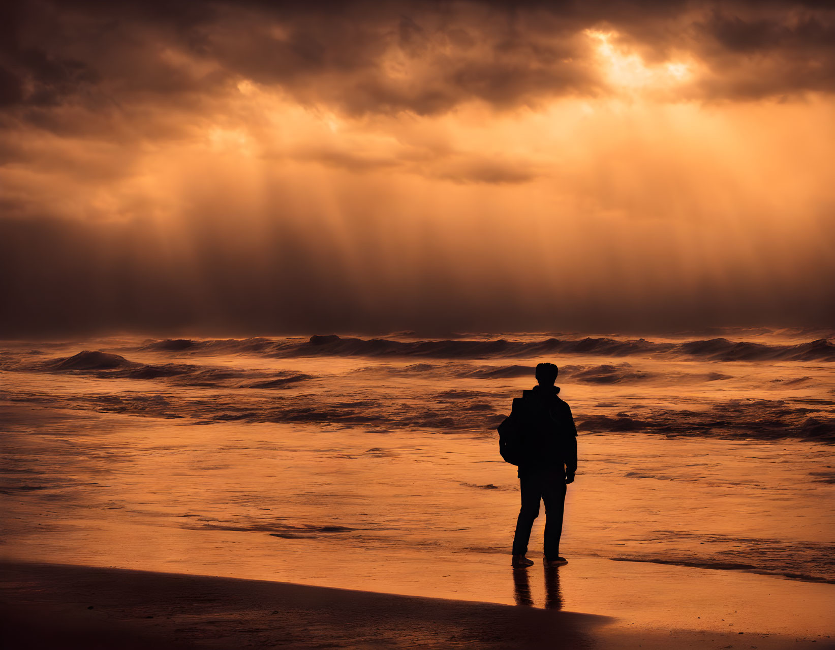 Silhouette of person on beach with dramatic sunlight and turbulent sea waves