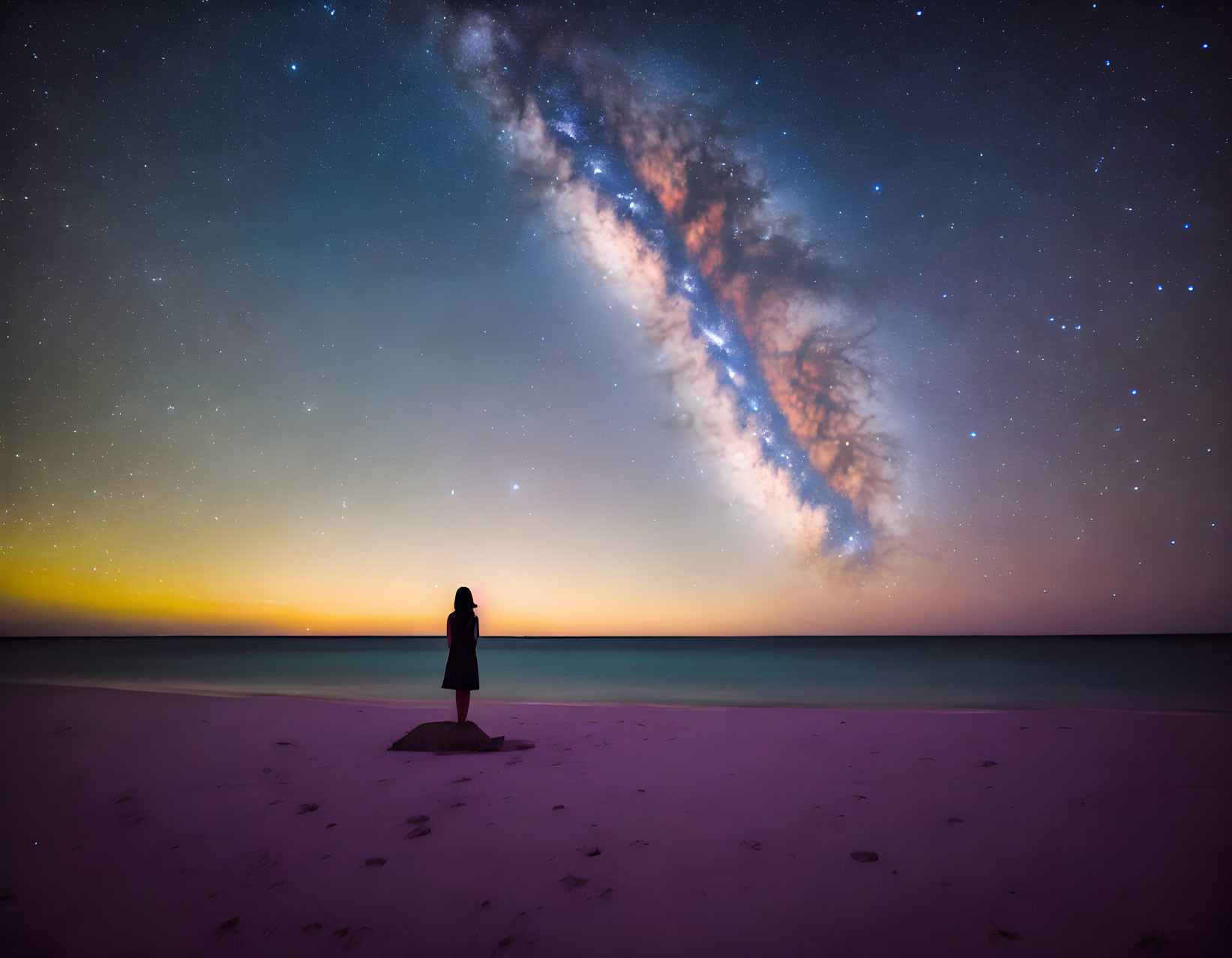 Starry sky over beach at twilight: Milky Way and horizon glow