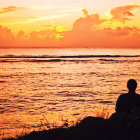 Person admiring sunset over tranquil sea with boats and cloud-dotted sky