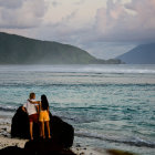 Silhouetted Figures on Cliff Overlooking Dramatic Sunset Seascape