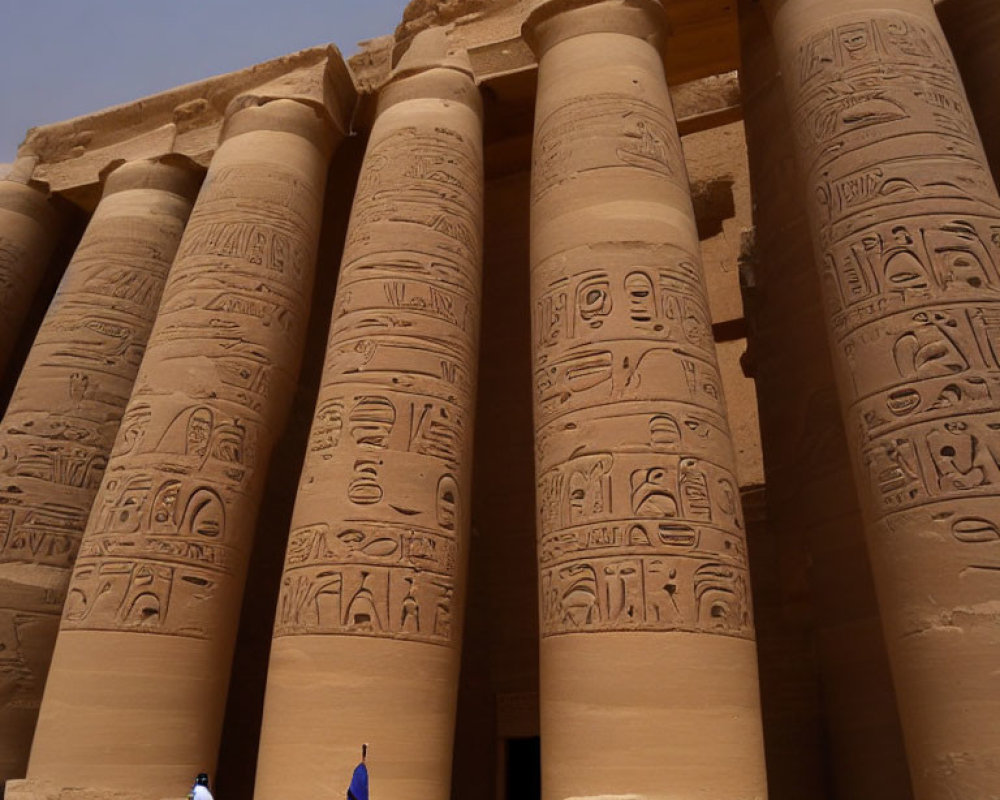 Traditional robed individuals at ancient Egyptian temple columns