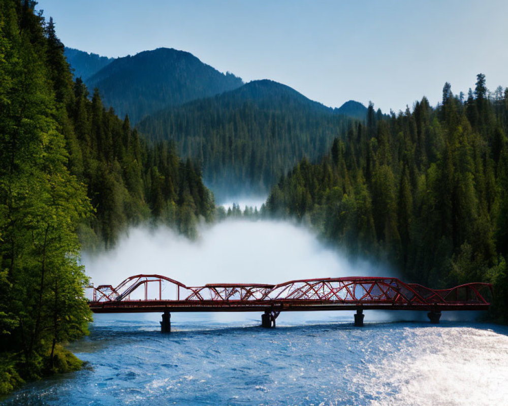 Red bridge over misty river with tree-covered hills under blue sky